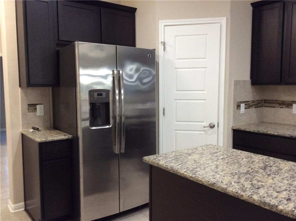 3451 Mayfield Ranch Boulevard, Unit 340 Round Rock, TX 78681 - Photo 7 of 13 A well-appointed kitchen showcasing a stainless steel refrigerator and elegant granite countertops.