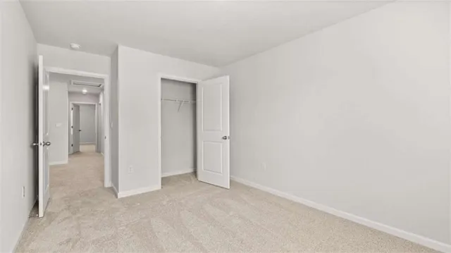 an empty room with closet and a bathroom