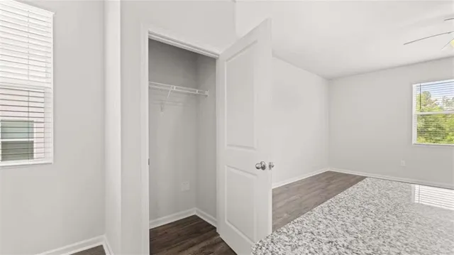 a view of hallway with window and hardwood floor