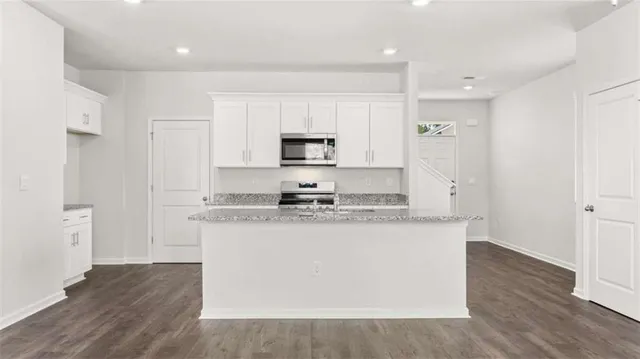 a kitchen with stainless steel appliances granite countertop a stove a sink and a refrigerator