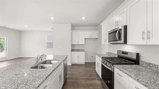 a kitchen with stainless steel appliances granite countertop a sink stove and refrigerator