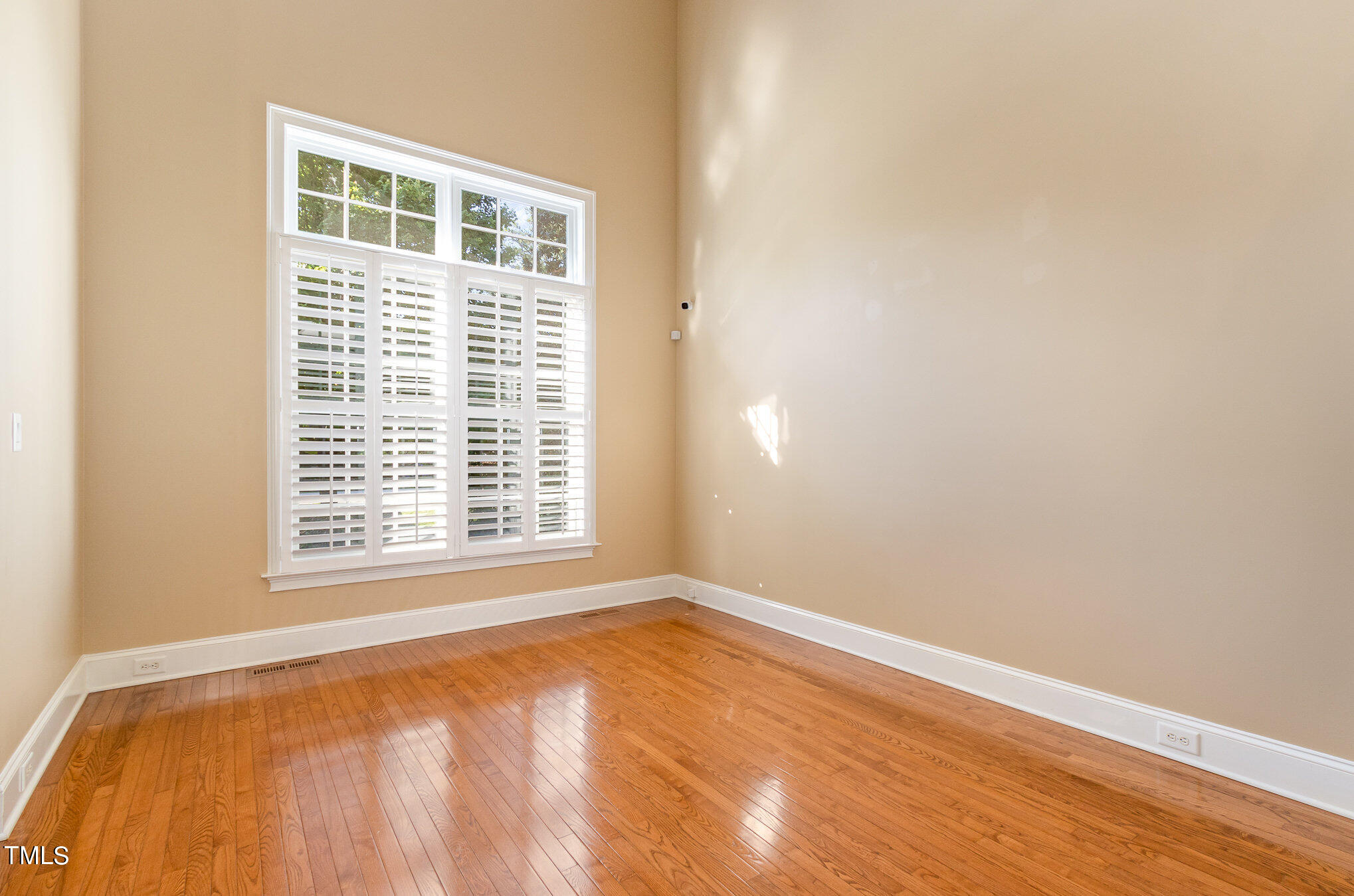 8319 La Matisse Road Raleigh, NC 27615 - Photo 8 of 46 a view of an empty room with wooden floor and a window