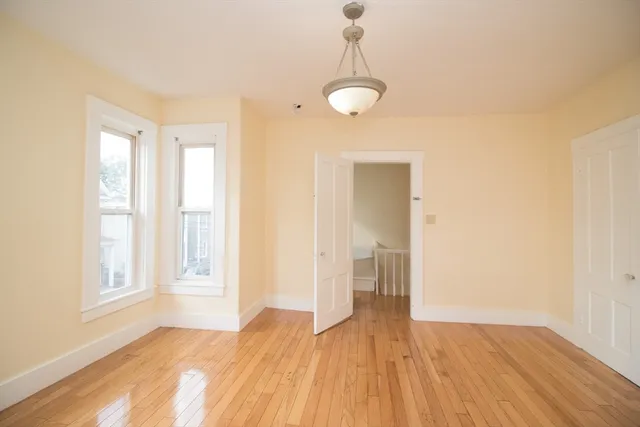 a view of empty room with wooden floor and window