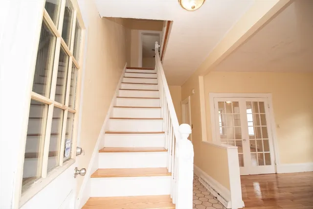a view of an entryway with wooden floor and door