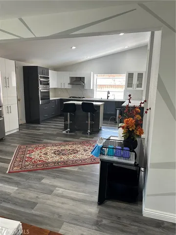 a living room with stainless steel appliances kitchen island granite countertop furniture and a fireplace