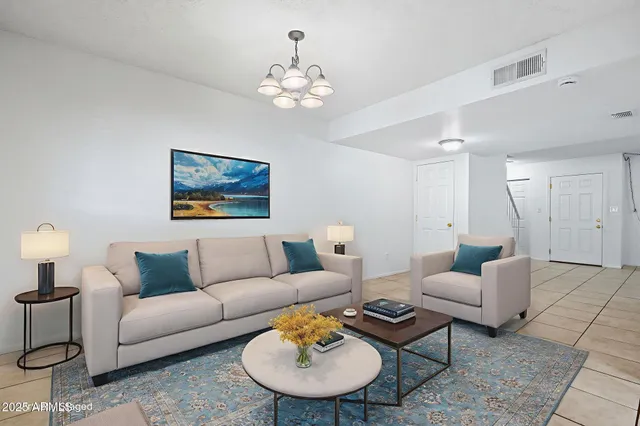 a living room with furniture a chandelier and a flat screen tv