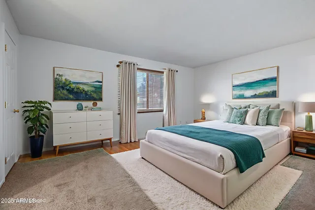 a bedroom with a bed and dresser with mirror