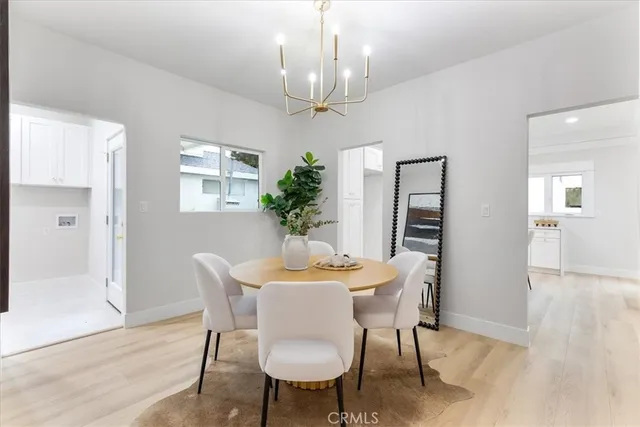 a dining room with furniture a chandelier and wooden floor