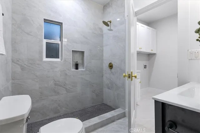 a bathroom with a granite countertop toilet sink and mirror
