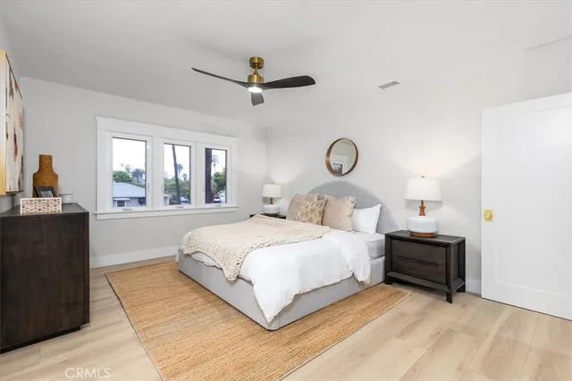 a bedroom with a bed and dresser with mirror