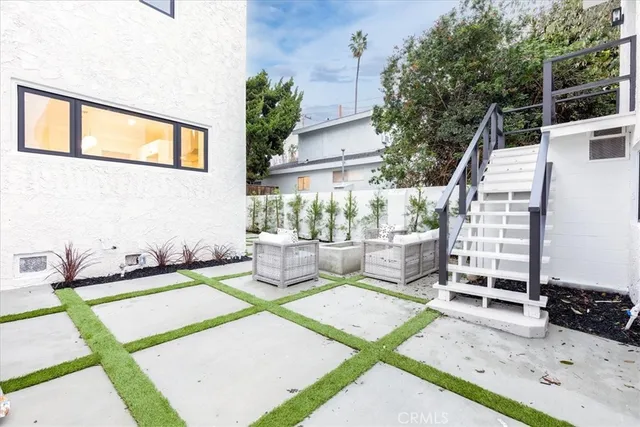 a view of a patio with couches table and chairs with wooden floor and fence