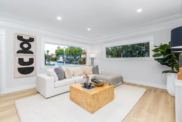 a living room with furniture a flat screen tv and a large window