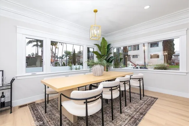 a dining room with furniture a chandelier and wooden floor