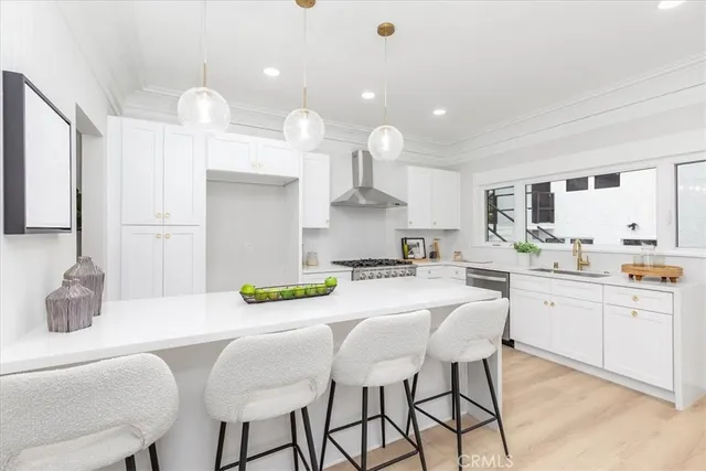 a kitchen with a dining table chairs and wooden floor