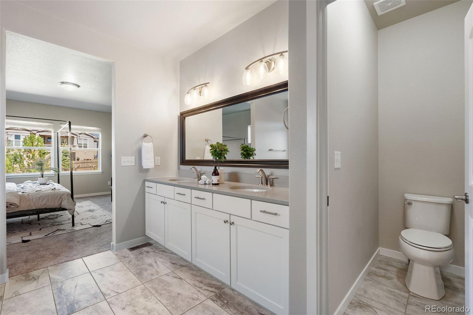 4508 Captain Jack Lane Colorado Springs, CO 80924 - Photo 22 of 50 a spacious bathroom with a toilet sink and a mirror