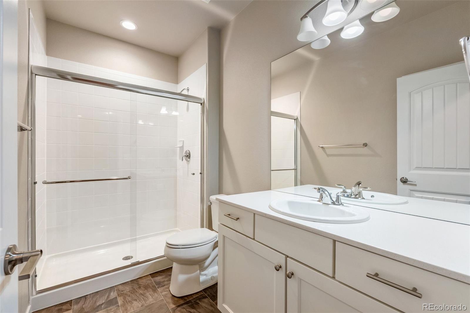 4508 Captain Jack Lane Colorado Springs, CO 80924 - Photo 29 of 50 a bathroom with a sink a toilet a mirror and shower