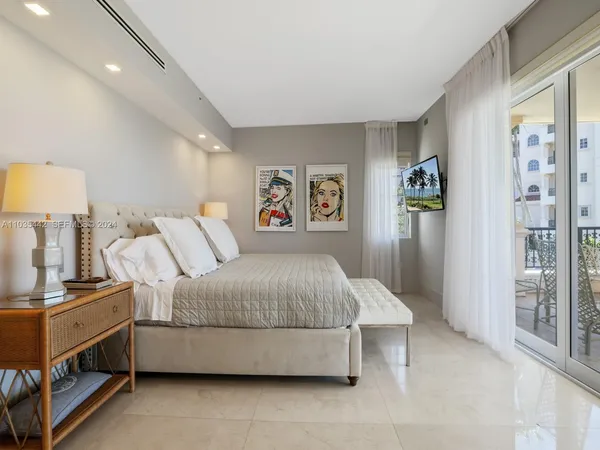 a spacious bedroom with a bed and a lamp