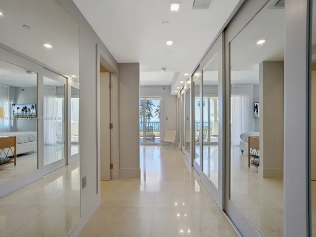 a view of a hallway with closet and a living room