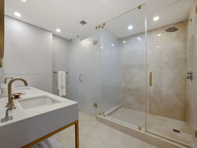 a bathroom with a sink shower and mirror