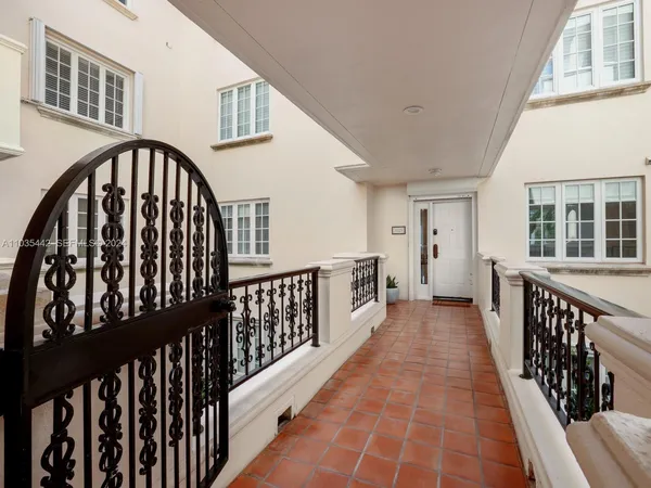 a swimming pool with a lawn chairs under palm trees