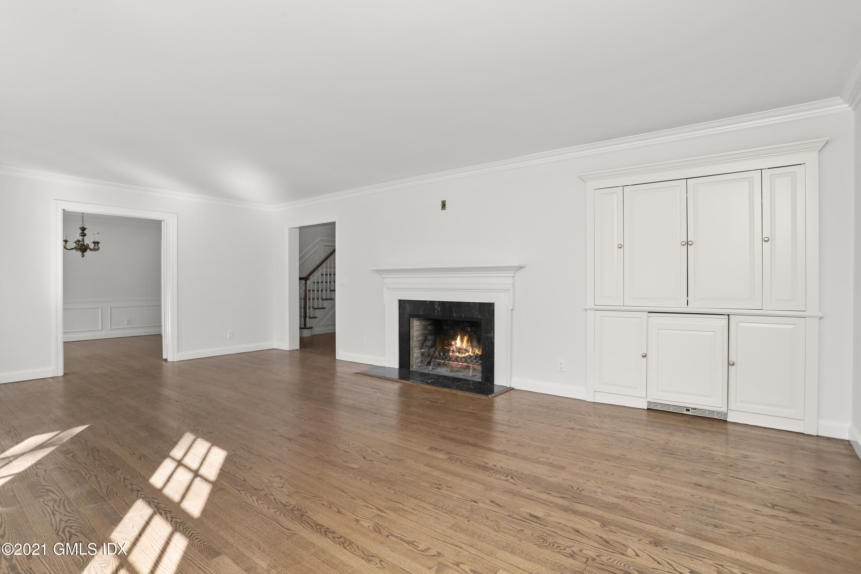 99 Hunting Ridge Road Greenwich, CT 06831 - Photo 12 of 23 a view of an empty room with wooden floor fireplace and a window