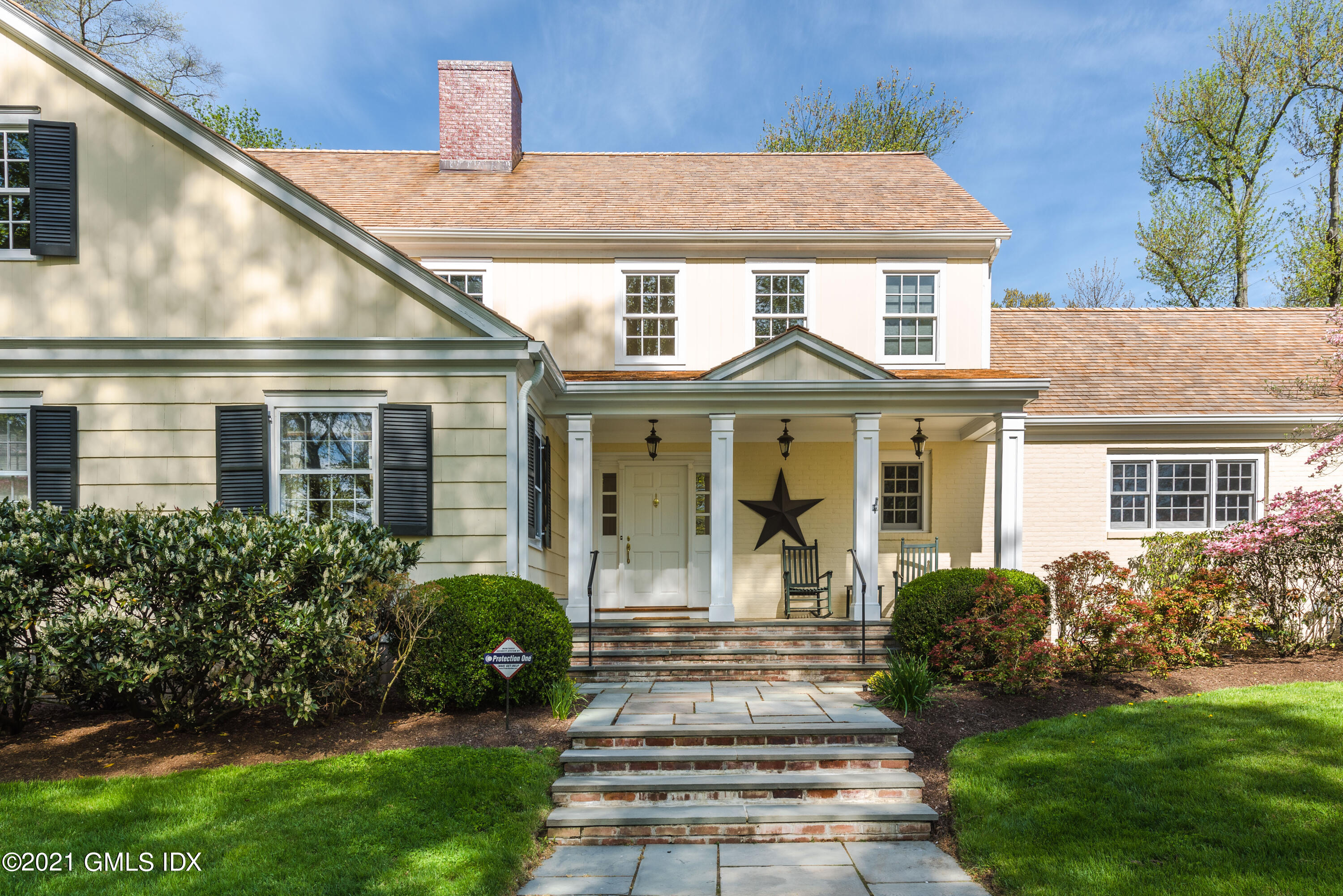 99 Hunting Ridge Road Greenwich, CT 06831 - Photo 3 of 23 a front view of a house with a garden