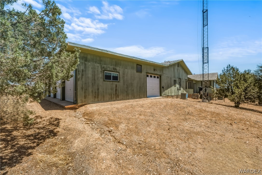 2401 North Stephan Road Kingman, AZ 86401 - Photo 19 of 92 Expansive exterior structure featuring light green vertical plank siding and a composite shingle roof