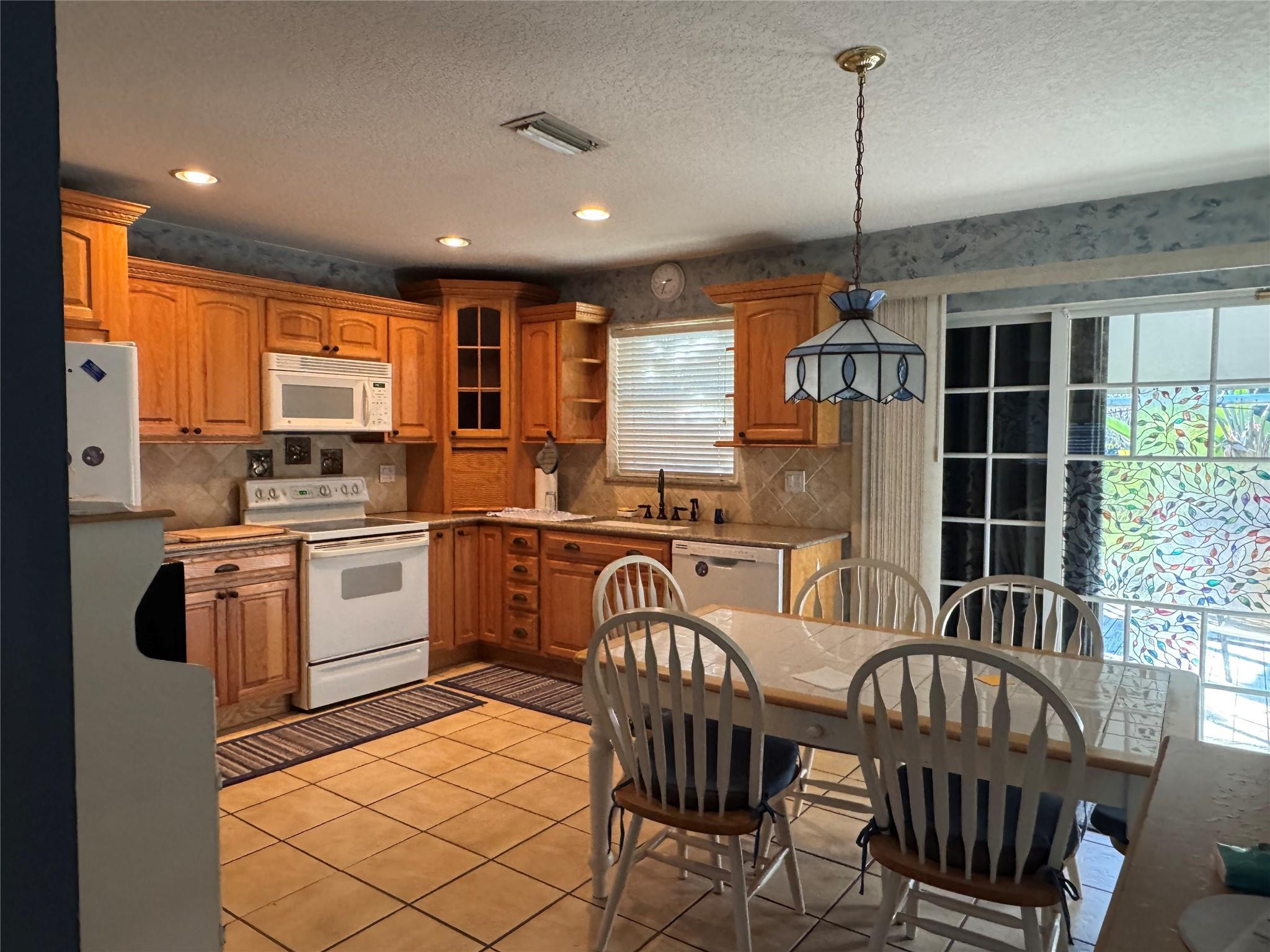 5221 Southwest 201st Terrace Southwest Ranches, FL 33332 - Photo 2 of 15 a kitchen with sink refrigerator dining table and chairs