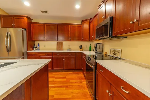 a kitchen with stainless steel appliances granite countertop a sink stove and refrigerator
