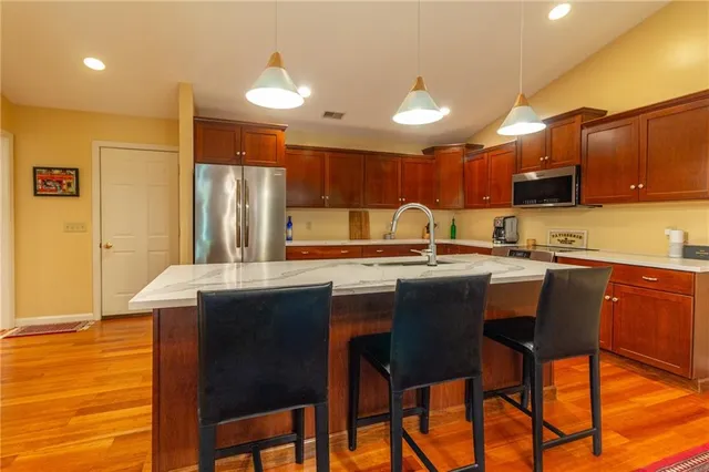 a kitchen with stainless steel appliances granite countertop table chairs sink and cabinets