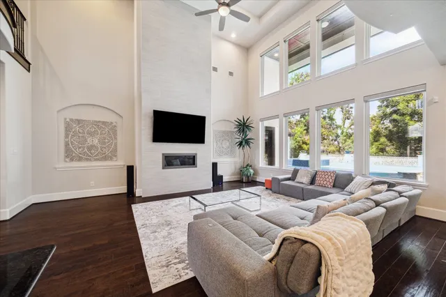 a kitchen with stainless steel appliances granite countertop a stove a sink and white cabinets with wooden floor