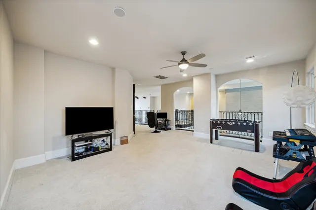 a spacious bedroom with a bed a chandelier and dresser