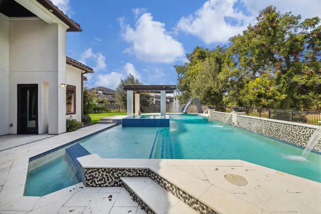 a view of a house with a yard potted plants and a large tree
