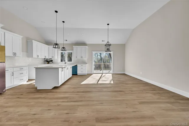 a large kitchen with cabinets and wooden floor