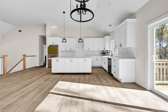 a room with kitchen island a wooden floor and white walls