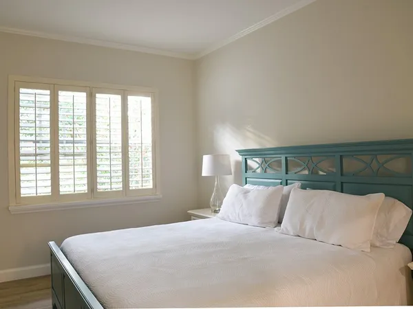 a room with a bed and a lamp on dresser