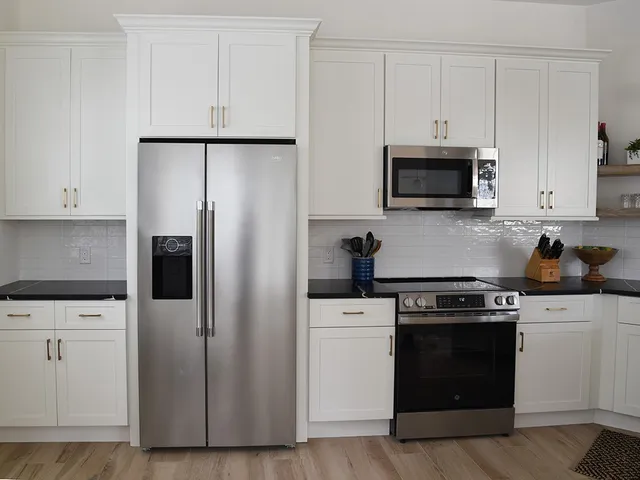 a kitchen with white cabinets and stainless steel appliances