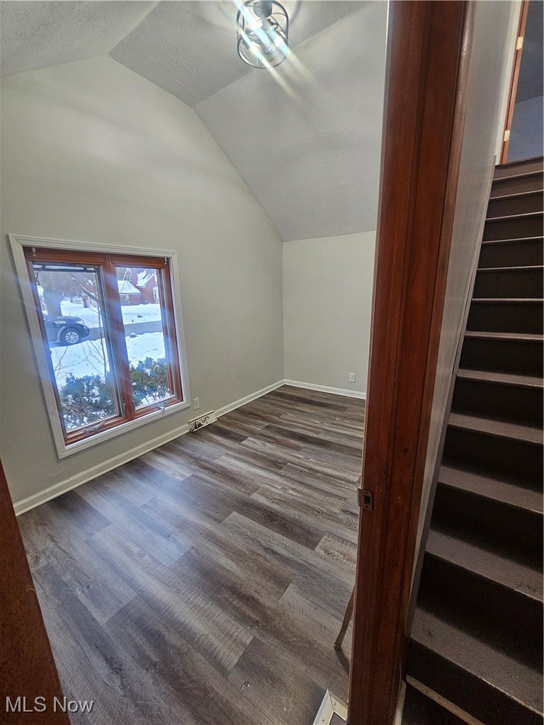 4495 Ammon Road Cleveland, OH 44143 - Photo 12 of 26 Additional living space featuring lofted ceiling, dark wood finished floors, stairway, and a textured ceiling
