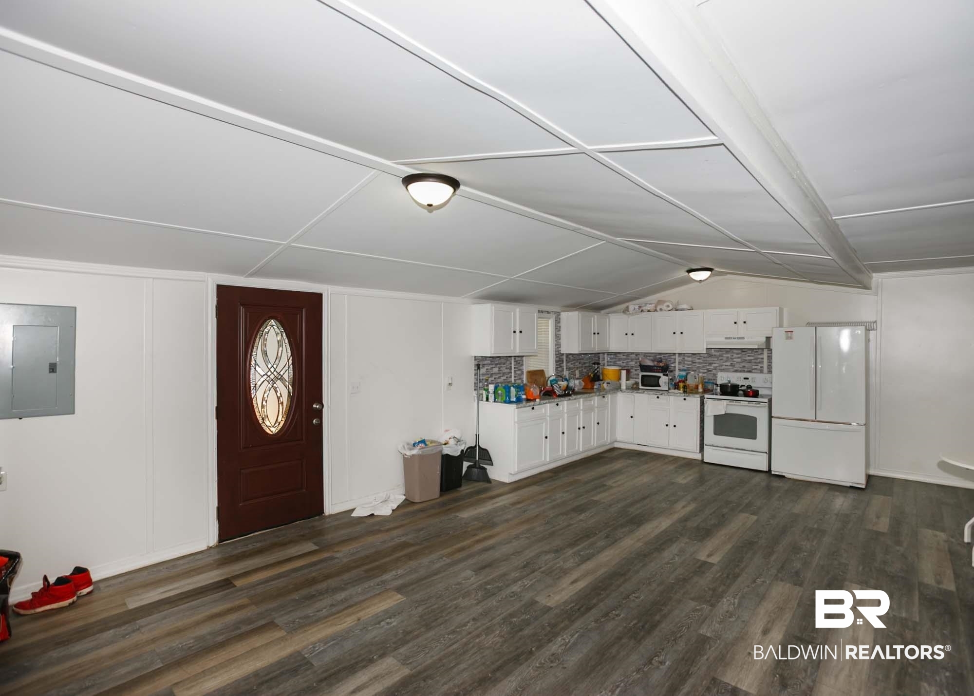 11998 Workman Avenue Foley, AL 36535 - Photo 16 of 59 Kitchen with white appliances, dark wood-type flooring, electric panel, white cabinetry, and backsplash
