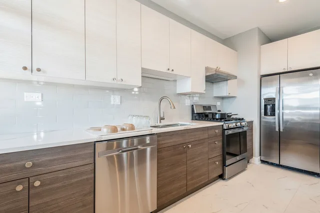 a kitchen with stainless steel appliances granite countertop a sink a stove and refrigerator