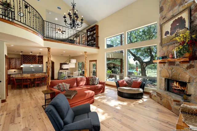 a living room with furniture a fireplace and a floor to ceiling window