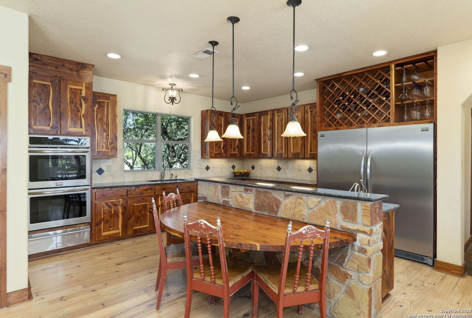 849 Madrona Ridge Drive Bandera, TX 78003 - Photo 13 of 44 a kitchen with kitchen island a large counter top space appliances and wooden floor
