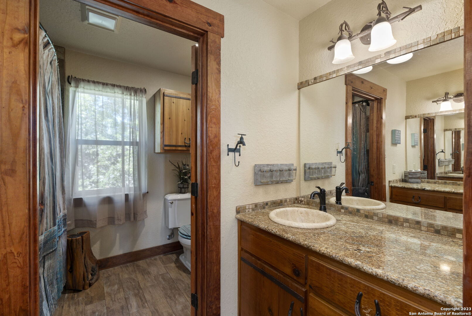 849 Madrona Ridge Drive Bandera, TX 78003 - Photo 30 of 44 a bathroom with a granite countertop sink a mirror and a shower