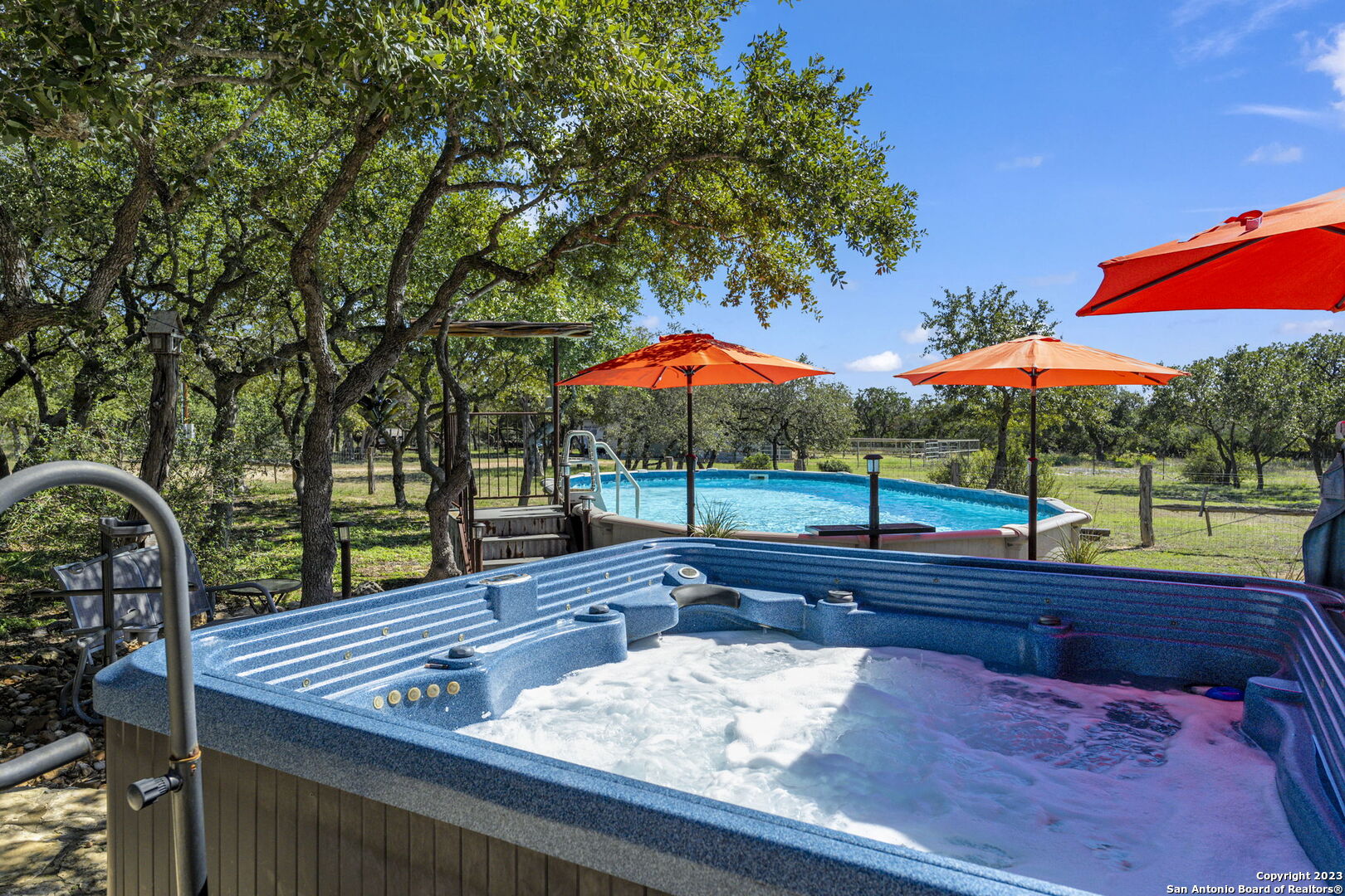 849 Madrona Ridge Drive Bandera, TX 78003 - Photo 35 of 44 a view of a backyard with a sink and table under an umbrella