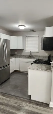 a kitchen with granite countertop white cabinets and white stove