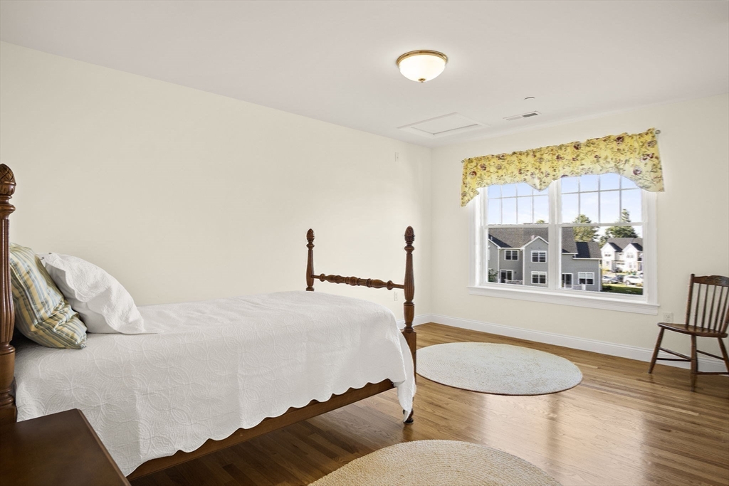 8 Winning Farm Road, Unit 8 Woburn, MA 01801 - Photo 25 of 42 a bedroom with a bed and wooden floor