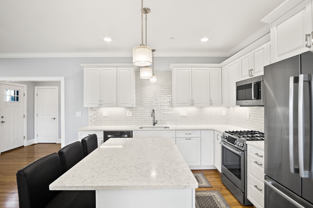 8 Winning Farm Road, Unit 8 Woburn, MA 01801 - Photo 4 of 42 a kitchen with a stove a sink and a refrigerator