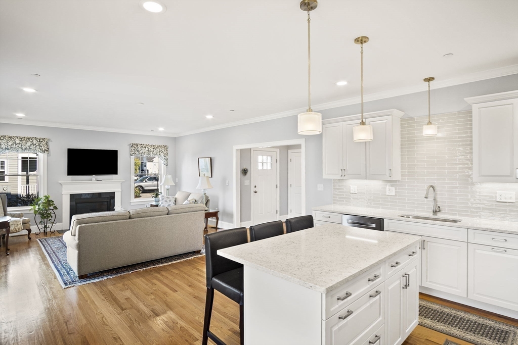 8 Winning Farm Road, Unit 8 Woburn, MA 01801 - Photo 7 of 42 a large white kitchen with a stove a sink a dining table and chairs