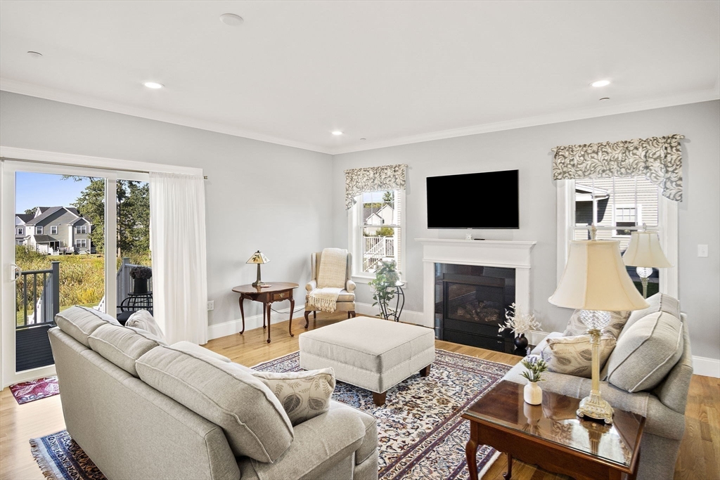 8 Winning Farm Road, Unit 8 Woburn, MA 01801 - Photo 9 of 42 a living room with furniture a fireplace and a flat screen tv