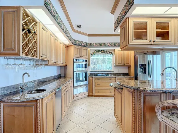 a kitchen with stainless steel appliances granite countertop a stove a sink and a refrigerator